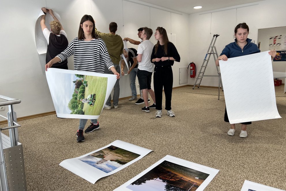 Studierende beim Aufh&auml;ngen der Bilder